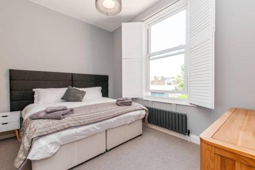 a bedroom with a large bed and a window at Serenity by the Sea - Broadstairs in Kent