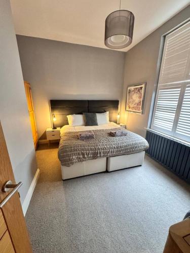 a bedroom with a bed and a large window at Serenity by the Sea - Broadstairs in Kent