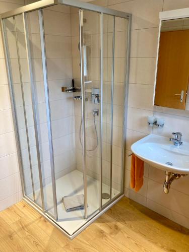 a glass shower in a bathroom with a sink at Chasa ARLU in Samnaun - Laret