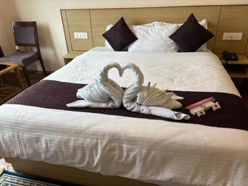 two swans making a heart on a bed at Hotel Swastik Inn in Gangtok