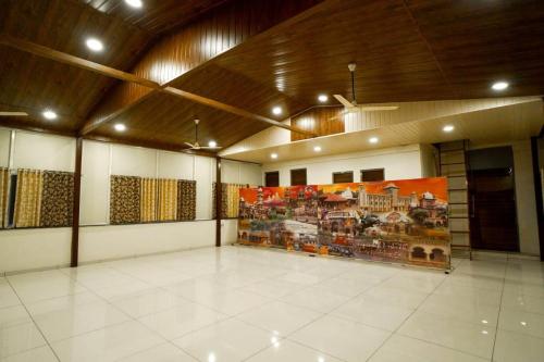 a large room with a large painting on the wall at Narayani lodge नारायणी लॉज in Kolhapur