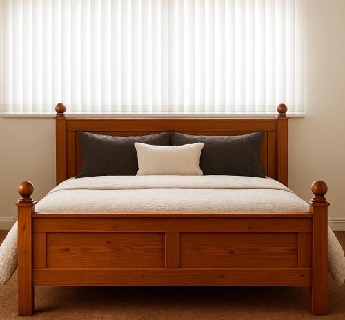 a bedroom with a wooden bed with a white blind at Budget Stay In Luton 01 D in Luton