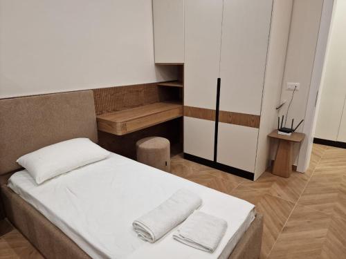 a bedroom with a bed with two towels on it at DURRES Beachfront Central TOP LOCATION APARTAMENTS in Durrës