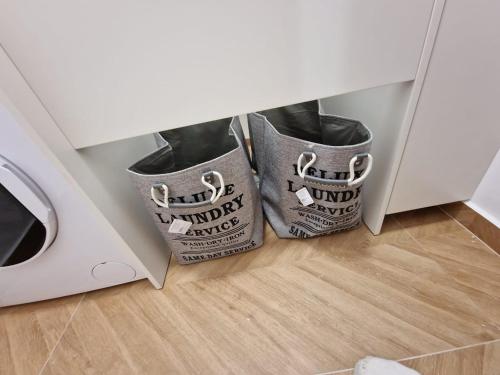 three trash cans in a cabinet next to a washing machine at DURRES Beachfront Central TOP LOCATION APARTAMENTS in Durrës