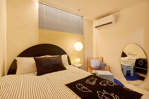a bedroom with a large bed and a mirror at Itaewon Mellow Stay#Namsan#Seoul Station#Hannam#Seongsu#Free Luggage in Seoul