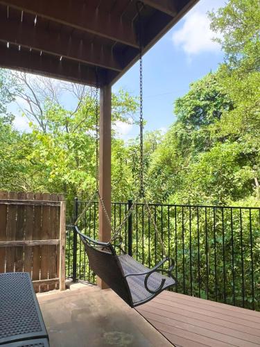 a hammock on a deck with a fence at Vacation Home with Whole Home Air Cleaner and Jacuzzi in Austin