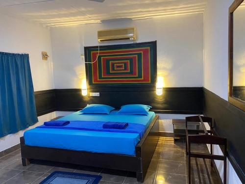 a bedroom with a bed and a painting on the wall at Crown Majesty in Arugam Bay