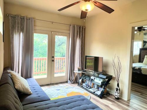 a living room with a blue couch and a tv at Vacation Home with Whole Home Air Cleaner and Jacuzzi in Austin