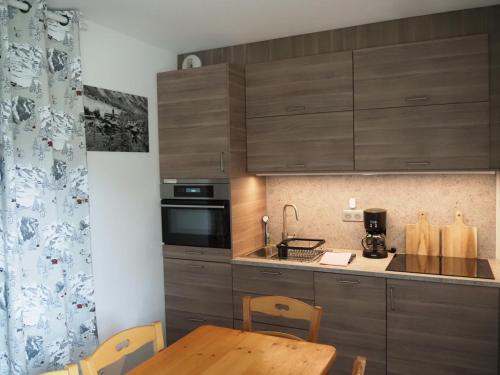 une cuisine avec des armoires en bois et une table en bois dans l'établissement Place du Montagnard à Termignon, à Termignon