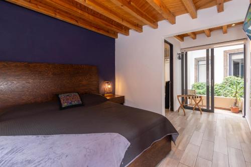 a bedroom with a large bed with a blue wall at LUXO Casa en San Miguel de Allende Centro con Vistas Panorámicas in San Miguel de Allende