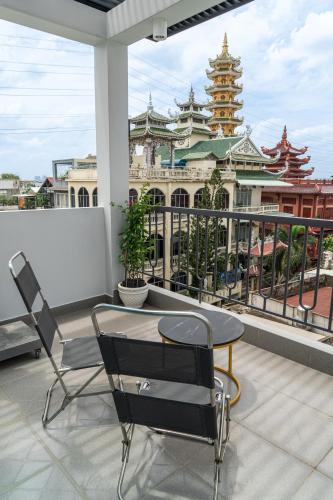 a table and chairs on a balcony with a building at Soul Station - Studio Hotel II in Ho Chi Minh City