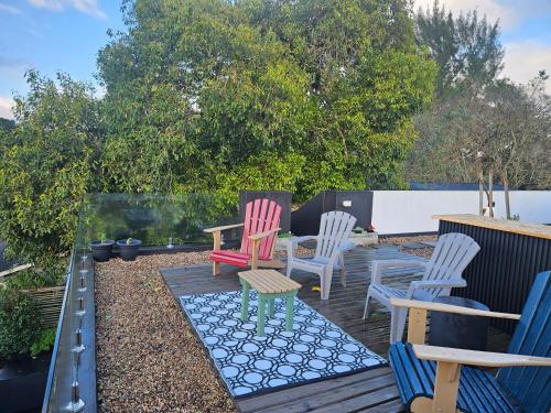 a group of chairs sitting on a wooden deck at Amoya Villa in St Lucia