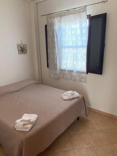 a bedroom with a bed and a window with towels at B&B direttamente sul mare da Antonino in Mattinata