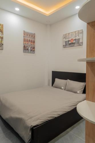 a bed in a room with a white wall at Soul Station - Studio Hotel II in Ho Chi Minh City