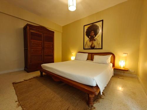a bedroom with a bed and a painting on the wall at Le Pleiadi in Malindi