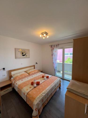 a bedroom with two beds and a large window at Apartman 4 Majba in Zaglavice