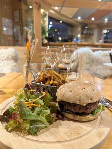 a plate with a sandwich and a salad and french fries at Hôtel-Chalet les Mélèzes in Valloire