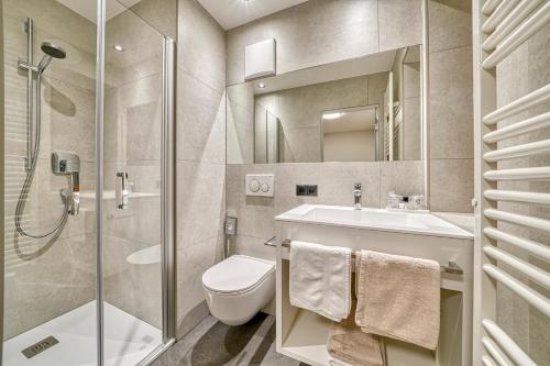 a bathroom with a toilet and a sink and a shower at Hotel Stefanie in Tirolo