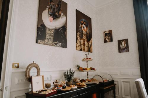 une pièce avec une table garnie de nourriture et des photos accrochées au mur dans l'établissement le petit château de Célestine, à Segonzac