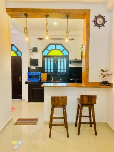 a kitchen with two bar stools and a counter at Star Nodes Villa in Galle