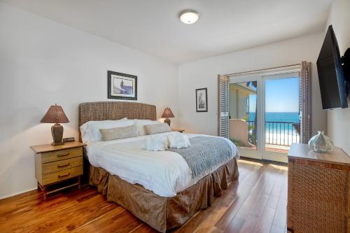 a bedroom with a bed with a view of the ocean at Exclusive Beachfront Duplex in Carlsbad Village Ocean Views, Sleeps 9 in Carlsbad