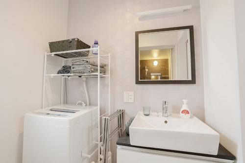 a white bathroom with a sink and a mirror at Bamboo Retreat Tofuku in Kyoto