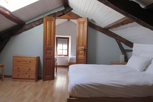 una camera da letto con letto bianco in mansarda di Le Mas des Cyprès a Constans