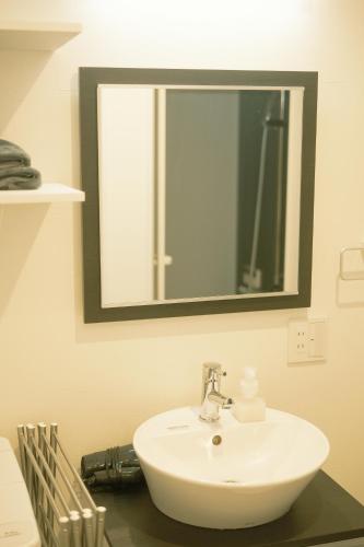 a bathroom with a white sink and a mirror at Bamboo Retreat Tofuku in Kyoto