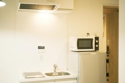a kitchen with a microwave and a refrigerator at Bamboo Retreat Tofuku in Kyoto