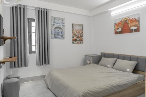 a white bedroom with a bed and a window at Soul Station - Studio Hotel II in Ho Chi Minh City