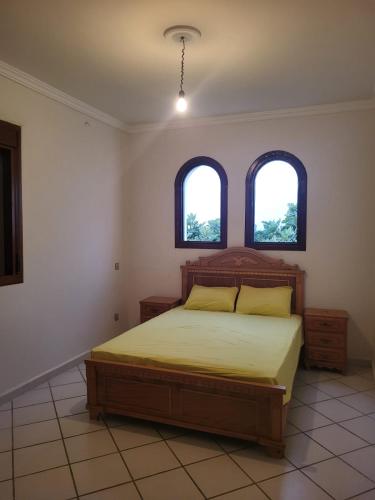 a bedroom with a bed and two windows at Villa CaboNegro 2 - Family only in Martil