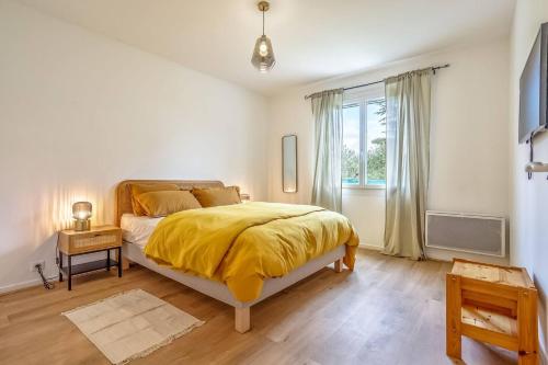 a bedroom with a bed with a yellow blanket on it at L'abeliano - House With Pool Near Uzs in Connaux
