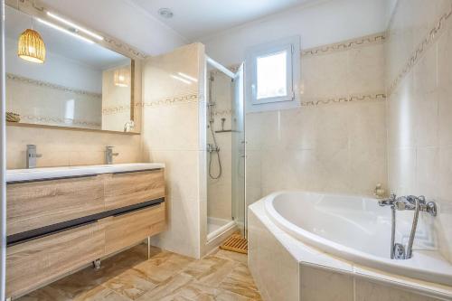 a bathroom with a tub and a shower and a sink at L'abeliano - House With Pool Near Uzs in Connaux