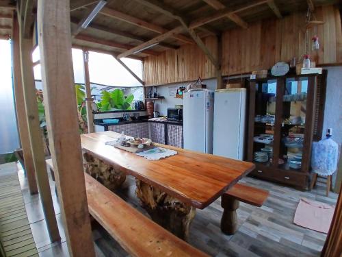 a kitchen with a wooden table and a refrigerator at Camping Urbano La Casita in Pedreiras