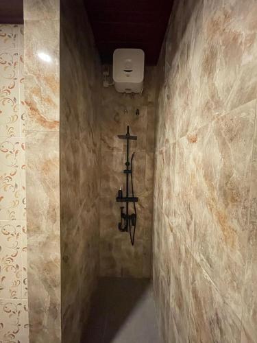 a bathroom with a cross hanging on the wall at Pradnya Homestay Ungasan - Room near Uluwatu in Uluwatu