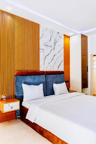 a bedroom with two beds and a blue headboard at Banora Apartments Gwarinpa in Gwarinpa