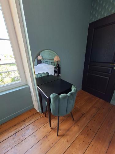 a bedroom with a desk and a bed and a chair at La Glycine in Luçon