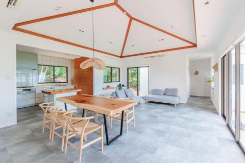 a kitchen and dining room with a wooden table and chairs at 呼吸する宿 ISHIGAKI Tida in Ishigaki Island