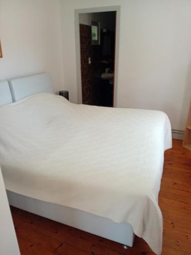 a bed with a white blanket on top of it at gite D ETAPE DU PELERIN de la butte aux oiseaux in Saint-Alban-sur-Limagnole