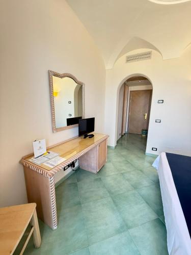 a room with a desk with a mirror at Hotel Albatros in Ischia