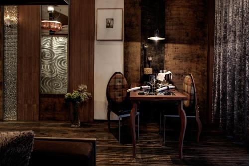 a dining room with a table and two chairs at Backstage Boutique SPA Hotel in Zermatt