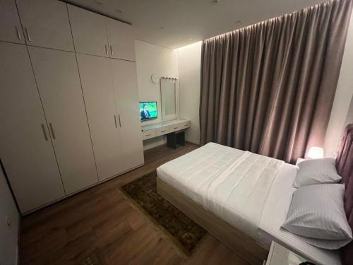 a bedroom with a bed and a television in it at فيلا فندقية بالشيخ زايد - Zayed Suites B in Sheikh Zayed