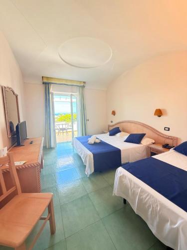 a hotel room with two beds and a balcony at Hotel Albatros in Ischia