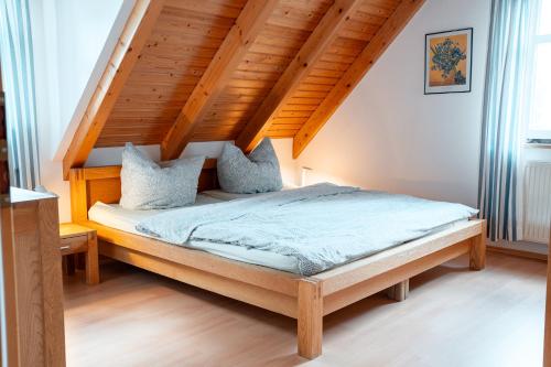 a bed in a room with a wooden ceiling at Altes Forsthaus im Harz in Elbingerode