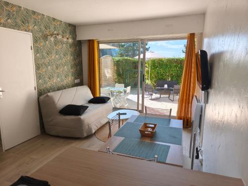 ベルニエール・シュル・メールにあるAppartement accès direct à la plageのソファとテーブルのあるリビングルーム