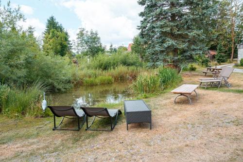 a group of chairs and tables next to a pond at Altes Forsthaus im Harz in Elbingerode