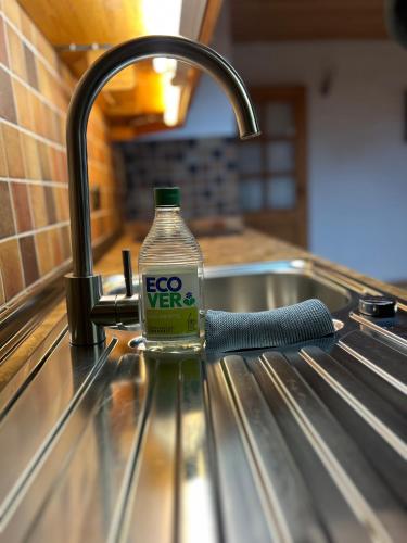 a bottle of evoc water sitting on top of a sink at Huberhof, Mettenham in Schleching