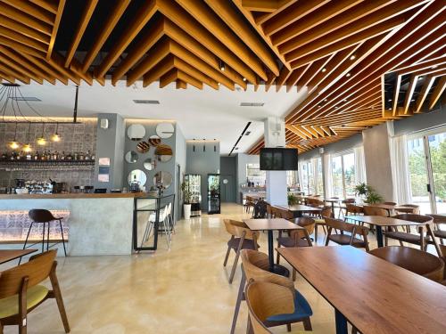 a restaurant with wooden ceilings and tables and chairs at Bel Ami Suita Hotel in Vlorë