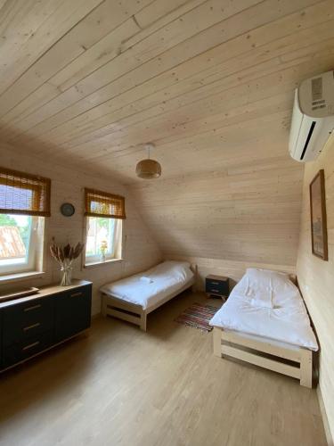two beds in a room with wooden walls at Osada California in Grudna