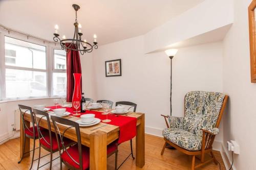 a dining room with a table and chairs at Magdala Cottage -Village Location- Dog Friendly in Kent